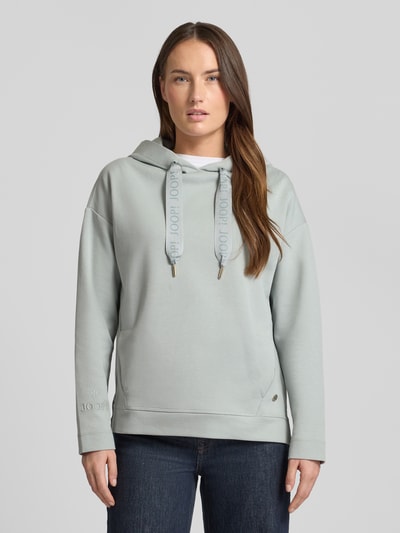 Vrouwenmodel draagt Regular Fit Hoodie met Logo-Applikation van JOOP!, katoenmix, elastische boorden, steekzakken, vooraanzicht bovenlichaam.