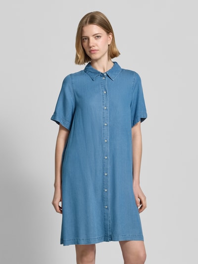 Frauenmodel trägt Tailliertes Jeanskleid aus Lyocell Modell 'BREE' von Vero Moda in Denim-Optik, Mini-Länge, V-Ausschnitt, Knopfleiste, Kurzarm, Material Lyocell, Ganzkörperansicht von vorne.