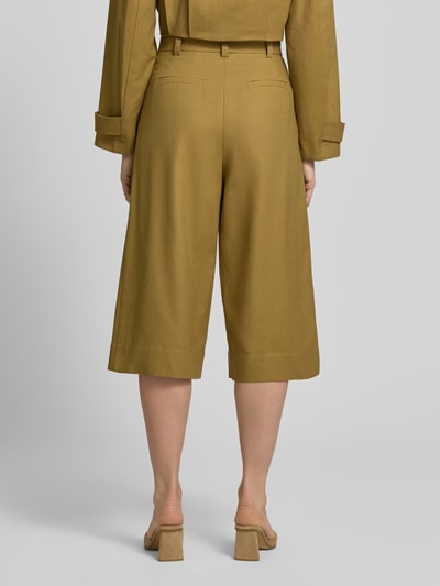 Frauenmodel trägt Bermudas aus Leinen-Baumwoll-Mix mit Gürtel von Style Icon Collection in Olivgrün, Relaxed Fit, Rückansicht, Ganzkörperansicht.