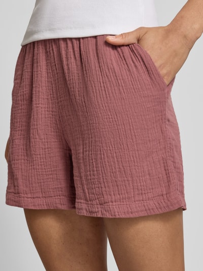 Kobiece model prezentuje Relaxed Fit Shorts aus reiner Baumwolle Modell 'THYRA' od Only, jednolity różowy crêpe, boczne kieszenie, zbliżenie na biodra