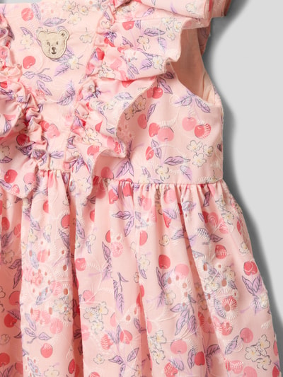Mädchen trägt Knielanges Kleid mit Rüschen und Motiv-Stitching von Steiff mit Material-Mix, A-Linie, rosa bedruckt, Nahaufnahme Oberkörper.