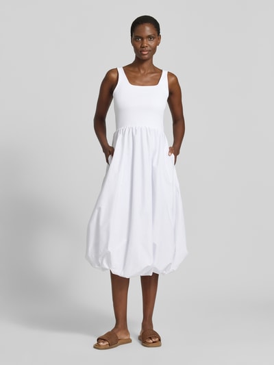 Frauenmodel trägt Ballonförmiges Midikleid im 2-in-1-Look von Rich & Royal aus Baumwoll-Elasthan-Mix, Karree-Ausschnitt, weiß, Ganzkörperansicht von vorne. Rückenlänge bei Größe S: 26 cm, Brustweite bei Größe S: 33 cm, ballonförmiger Schnitt.