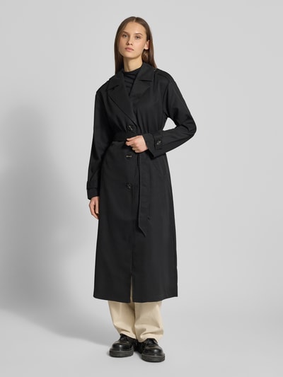 Frauenmodel trägt Regular Fit Trenchcoat in Longline Modell 'LINE' von ONLY, Optik: Unifarben, Reverskragen, einreihige Knopfleiste, Gehschlitz, Schulterriegel, seitliche Eingrifftaschen, Langarm mit Riegel, Ganzkörperansicht von vorne.
