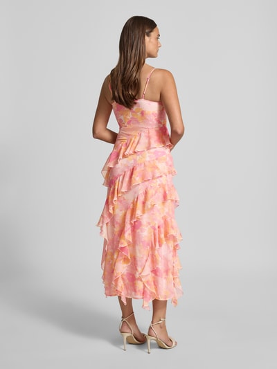 Männermodel trägt figurbetontes Midikleid mit Rüschen Modell 'SMILLA' von Vero Moda aus Chiffon, różowy wzór polka dots, długość midi, bez rękawów, V-dekolt, falbanki, cienkie ramiączka, z podszewką i krytym zamkiem, całkowity widok od tyłu