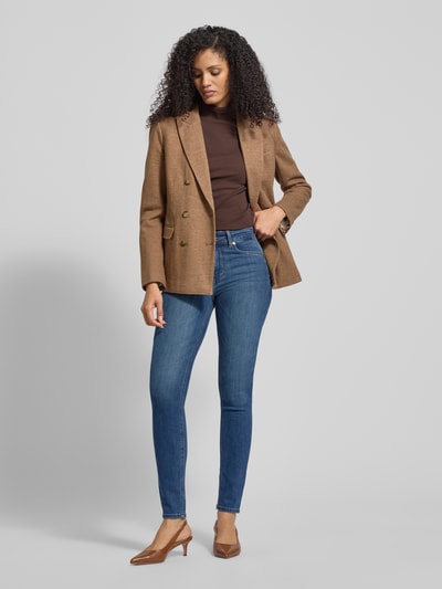 Frauenmodel trägt Skinny Fit Jeans mit Ziersteinbesatz Modell 'DIVINE' von Liu Jo White, Baumwoll-Mix mit Stretch-Anteil, Eingrifftaschen, mittelblaue Waschung, Ganzkörperansicht von vorne.