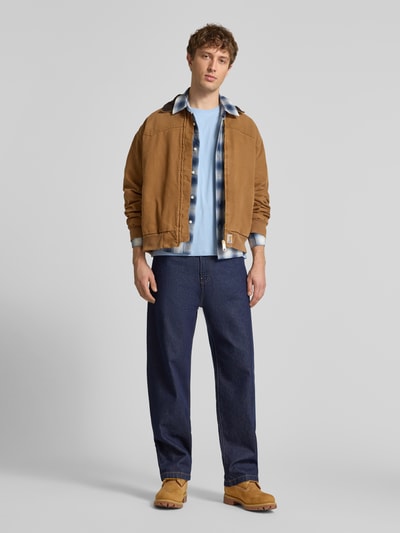 Męski model nosi T-Shirt mit Label-Patch od Alpha Industries z bawełny, prosty krój, okrągły dekolt, długość tyłu 66 cm, Ganzkörperansicht von vorne.
