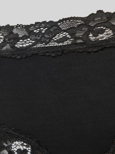 Frauenmodel trägt schwarze Slim Fit Panties mit Spitzenbesatz von Skiny, elastischer Micromodal-Mix, florale-Optik, Nahaufnahme Hüfte.