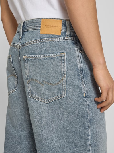 Männermodel trägt Extra Baggy Fit Bermudas Modell 'IRON' von Jack & Jones aus bawełna, wpuszczane kieszenie, szerokość w rozmiarze M: 45 cm, długość wewnętrzna nogawki: 31 cm, kolor jasnoniebieski, widoczna faktura denim, Ganzkörperansicht Rückansicht.