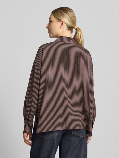 Vrouwenmodel draagt Relaxed Fit blouse met all-over look van DRYKORN, Viscosemix, Model 'CLOELIA', overhemdkraag, knoopsluiting, schouders met verlaagde mouwinzet, ruglengte maat 36 74 cm, mouwlengte 51 cm, donkere en lichte strepen, zachte textuur, donkere jeans, volledige achteraanzicht.