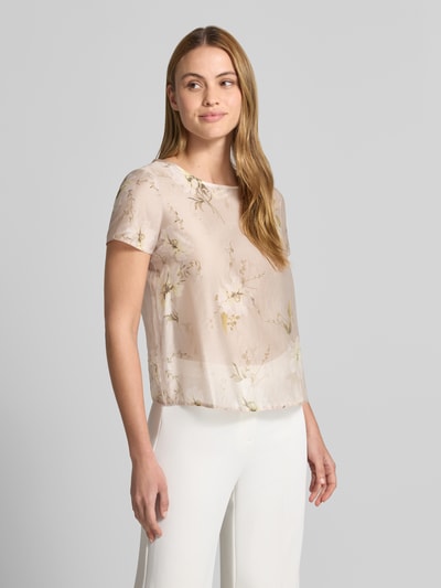 Frauenmodel trägt Blusenshirt mit Rundhalsausschnitt und abgerundetem Saum von Rinascimento, Lyocell-Mix, zartes Beige mit floralen Mustern, Loose Fit, Ganzkörperansicht von vorne.
