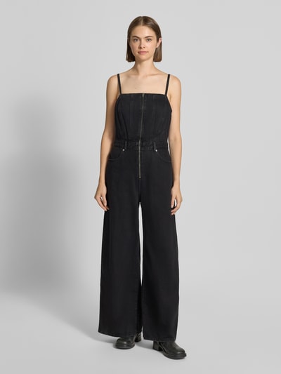 Modelka prezentuje czarny kombinezon Regular Fit Jumpsuit aus reiner Baumwolle Modell 'SEAMED' od Levi's® 300, gładka tekstura, całkowity widok z przodu.