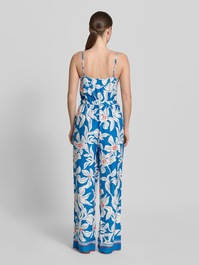 Vrouwenmodel draagt Jumpsuit uit viscose met spaghettibandjes model 'Rylie' van GUIDO MARIA KRETSCHMER WOMAN, getailleerd model, ruglengte maat 36: 128 cm, borstwijdte maat 36: 32 cm, strikceintuur, ronde hals, blauwe stof met witte bloemenprint, totale lengte 128 cm, binnenbeenlengte 78 cm. Ganzkörperansicht Rückansicht.