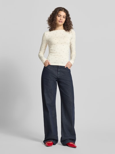Frauenmodel trägt Longsleeve mit Viskose-Anteil von OH APRIL in Creme mit feinem Muster, U-Boot-Ausschnitt, körpernah, Ganzkörperansicht von vorne.
