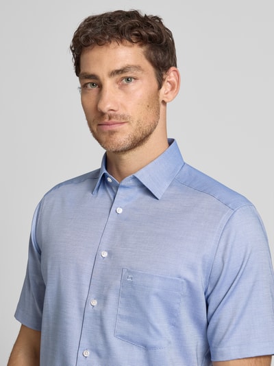 Männermodel trägt Regular Fit Business-Hemd mit Kentkragen von OLYMP in Hellblau, Unifarbenes-Design, Strukturmuster, Nahaufnahme Oberkörper.