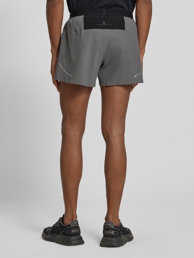 Männermodel trägt Relaxed Fit Shorts mit integriertem Slip von EA7 Emporio Armani, Elastischer-Material-Mix, Strukturmuster, Logo-Patch, Elastischer Bund, Ganzkörperansicht Rückansicht.