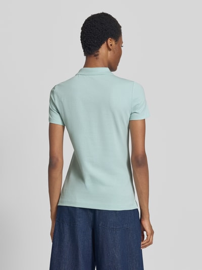 Frauenmodel trägt Regular Fit Poloshirt aus reiner Baumwolle von Tom Tailor in Hellblau, glatte Textur, Damen Poloshirt, Ganzkörperansicht Rückansicht.