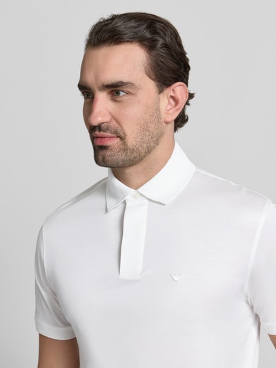 Männermodel trägt Poloshirt mit kurzer Knopfleiste von Emporio Armani in Weiß, Lyocell-Baumwoll-Mix, Nahaufnahme Oberkörper.