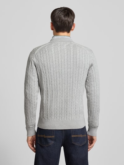 Männermodel trägt Regular Fit Strickpullover aus reiner Baumwolle von Tommy Hilfiger, Optik: Unifarben, Zopfmuster, Ganzkörperansicht Rückansicht.