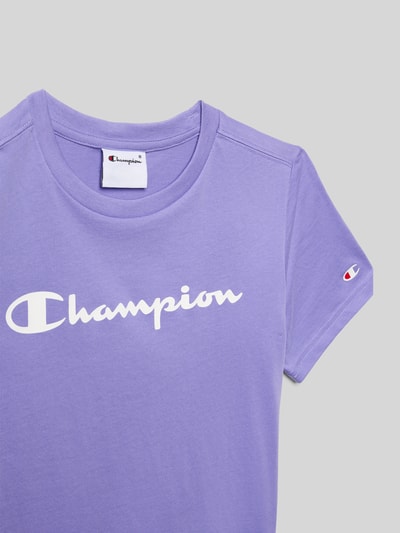 Produktfoto, T-Shirt aus reiner Baumwolle von Champion in Flieder mit weißem Label-Print, Rundhalsausschnitt und gerader Passform.