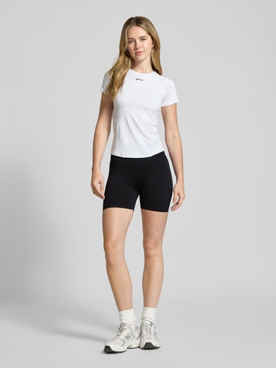 Modelka kobieca nosi Radlerhose mit elastischem Bund Modell 'Shape Seamless' od aim'n, czarna, dopasowany materiał ze stretchem, pełny przód, Ganzkörperansicht von vorne