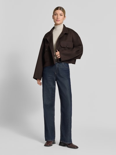 Frauenmodel trägt Boxy Fit Jacke mit Stehkragen Modell 'ARKLOW' von DRYKORN im Baumwoll-Mix, dunkelbraun, Pattentaschen, Ganzkörperansicht von vorne.