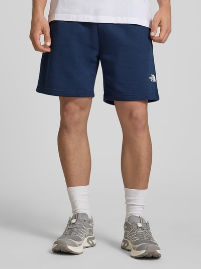 Männermodel trägt Shorts mit Logo von The North Face aus dunkelblauem Baumwoll-Mix, Regular-Fit, elastischer Bund, Ganzkörperansicht von vorne.