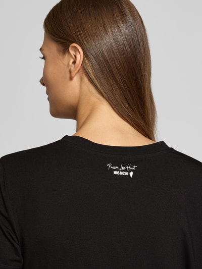 Vrouwenmodel draagt zwart regular fit t-shirt van MOS MOSH, Model 'Dala', jersey, label-embleem, ruglengte maat S 58 cm, Ganzkörperansicht Rückansicht.