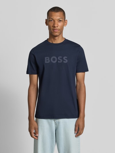 Männermodel trägt Regular Fit T-Shirt aus reiner Baumwolle Modell 'Te_Logo' von BOSS für Herren BOSS Orange, dunkelblau, Ganzkörperansicht von vorne.