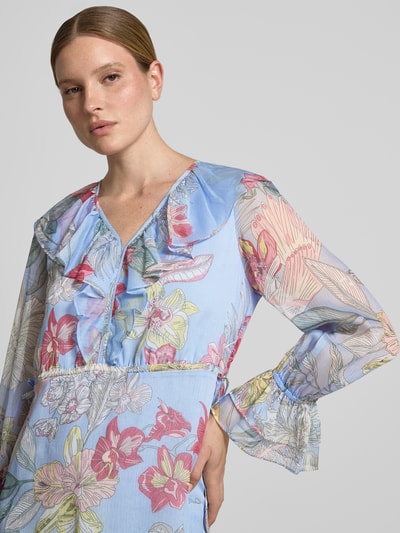 Frauenmodel trägt Knielanges Kleid mit V-Ausschnitt und Volants von Comma aus Chiffon im bunten Allover-Look, Nahaufnahme Oberkörper.