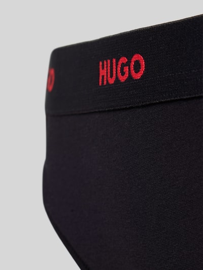 Kobiecy model nosi Stringi z mieszanki bawełny Model 'HUGO ID THONG' od HUGO, efekt: jednolity kolor, napis z logo, elastyczny ściągacz, mieszanka bawełny, detal: zbliżenie na biodro.