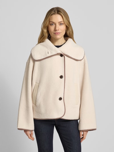 Kobiece model nosi Boxy Fit Fleecejacke mit Eingrifftaschen Modell 'romane' od VARLEY, kremowa kurtka z kołnierzem i kieszeniami, przód, ujęcie całej sylwetki.
