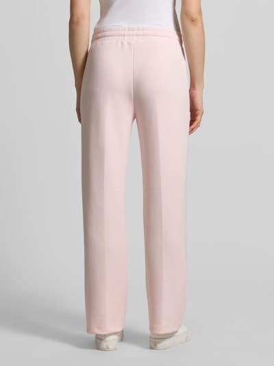 Kobiece modelka nosi Sweatpants mit Label-Applikation Modell 'Talila' von JOOP!, jasnoróżowy kolor, prosty krój, elastyczny pas, szerokość w rozmiarze 36: 40 cm, długość nogawki od wewnątrz w rozmiarze 36: 80 cm, widok całej sylwetki z tyłu