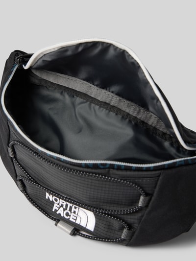 Produktfoto, Bauchtasche mit Logo-Print Modell 'Jester' von The North Face, schwarzes Material, Reißverschluss, sichtbare Struktur, Herren Bauchtasche, Hauptfach geöffnet, verstellbarer Schulterriemen, Maße: 27x16x9 cm, neutraler Hintergrund