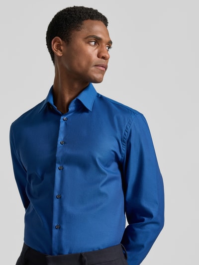 Männermodel trägt Slim Fit Business-Hemd mit Kentkragen von Jake*s in Blau aus Reine Baumwolle mit Knopfleiste, Sportmanschetten und abgerundetem Saum, Nahaufnahme Oberkörper. Rückenlänge 79 cm, Schulterbreite 48 cm, Ärmellänge 65 cm, Größe 39/40.