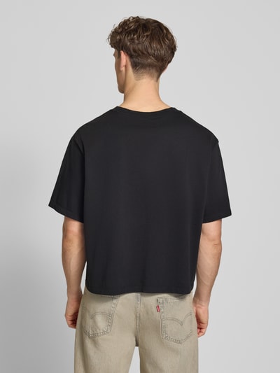 Männermodel trägt Relaxed Fit T-Shirt aus reiner Baumwolle von Calvin Klein Jeans, Optik: Unifarben, Label-Print, Ganzkörperansicht Rückansicht.