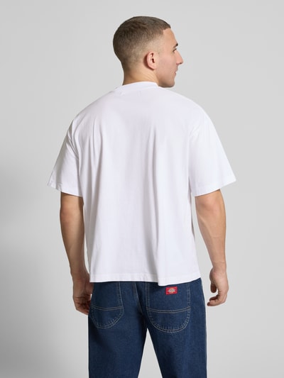 Männermodel trägt Regular Fit T-Shirt mit Logo-Detail von ANOTHER COTTON LAB, reine Baumwolle, weiß, glatte Textur, Rückenansicht, Ganzkörperansicht Rückansicht.