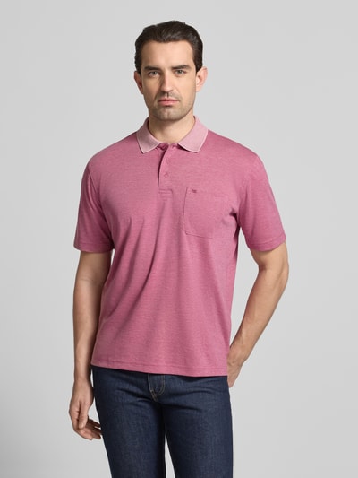 Männermodel trägt Regular Fit Poloshirt mit Brusttasche von Christian Berg Men im Material-Mix mit Baumwoll-Anteil, Ganzkörperansicht von vorne.