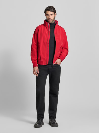 Männermodel trägt Regular Fit Jacke mit Kapuze Modell 'Como' von NAUTGÅRD in Rot, Zweiwegereißverschluss, Ganzkörperansicht von vorne.
