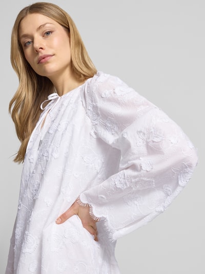 Frauenmodel trägt Minikleid mit Spitze und Kimonoärmeln von MICHAEL Michael Kors in Weiß, Serafino-Ausschnitt, Nahaufnahme Oberkörper.