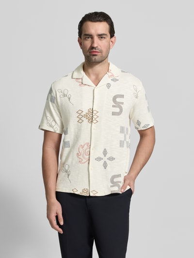 Männermodel trägt Slim Fit Freizeithemd mit Allover-Motiv-Stitching von MCNEAL, cremefarben mit grafischem Muster, Nahaufnahme Oberkörper. Reine Baumwolle, Reverskragen, kurzärmelig, durchgehende Knopfleiste.