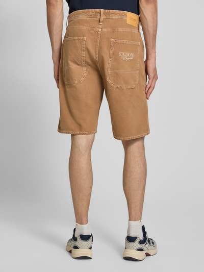 Męskimodel nosi Baggy Fit Jeansshorts mit Eingrifftaschen Modell 'ALEX' von JACK & JONES, bawełna, szerokość w rozmiarze M: 46 cm, długość wewnętrzna nogawki w rozmiarze M: 28 cm, wpuszczane kieszenie, kolor jasnobrązowy, tekstura gładka, całkowity widok z tyłu