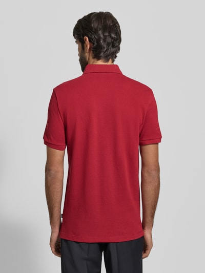 Männermodel trägt Regular Fit Poloshirt aus reiner Baumwolle Modell 'QIANG' von BOSS in Optik: Unifarben, Ganzkörperansicht Rückansicht.