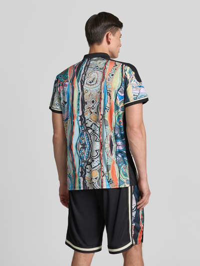 Männermodel trägt Slim Fit T-Shirt mit Label-Print von COLUCCI, bunte Muster, Polokragen, Rückenlänge M 72 cm, Ganzkörperansicht Rückansicht.