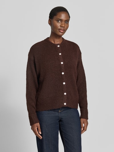 Modelka prezentuje kardigan rozpinany z elastycznej mieszanki materiałów z dodatkiem wełny, krój relaxed fit, Model 'Belablue' od ICHI, ciemny brąz, okrągły dekolt, długie rękawy, prążkowane ściągacze, długość tyłu 57 cm, długość rękawów 71 cm, widok całej sylwetki z przodu.
