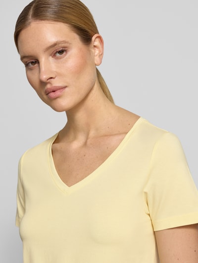 Kobiece model nosi damski t-shirt Regular Fit T-Shirt aus Baumwoll-Mix od s.Oliver RED LABEL, efekt: jednolity kolor, dekolt w serek, krótki rękaw, wykończenie materiału: dżersej, mieszanka bawełny, jasny żółty kolor, gładka faktura, zbliżenie górnej części ciała, przód.