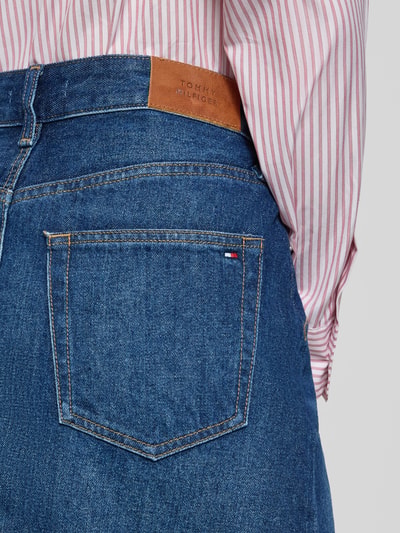 Frauenmodel trägt Körpernaher Jeansrock aus reiner Baumwolle von Tommy Hilfiger, Optik: Unifarben, Denim, Label-Patch, Logo-Detail, Nieten, 5-Pocket-Design, Ganzkörperansicht Rückansicht.