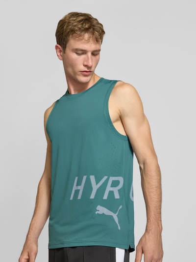 Männermodel trägt Regular Fit Sport-T-Shirt mit Rundhalsausschnitt von PUMA Performance in Türkis mit grauem Logo, Nahaufnahme Oberkörper