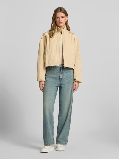 Frauenmodel trägt Jacke mit verdecktem Reißverschluss Modell 'Romina' von LeGer by Lena Gercke in Beige, gerader Schnitt, Ganzkörperansicht von vorne.