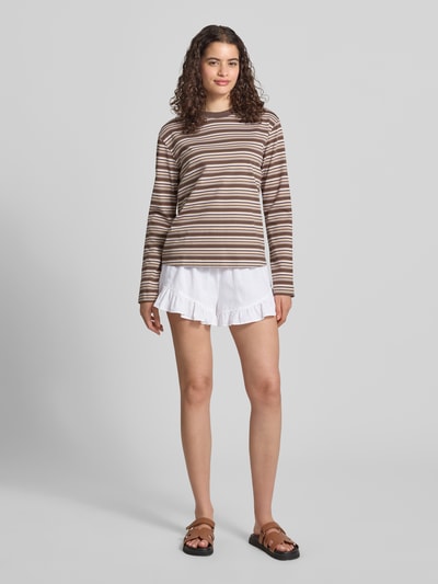 Frauenmodel trägt Shorts aus Leinen-Mix mit Rüschen am Saum von Gina Tricot, weiß, Loose Fit, elastischer Bund, Ganzkörperansicht von vorne.