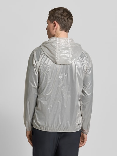 Männermodel trägt Blouson mit Label-Print von EA7 Emporio Armani, semitransparent, silbergrau, elastische Abschlüsse, Ganzkörperansicht Rückansicht.